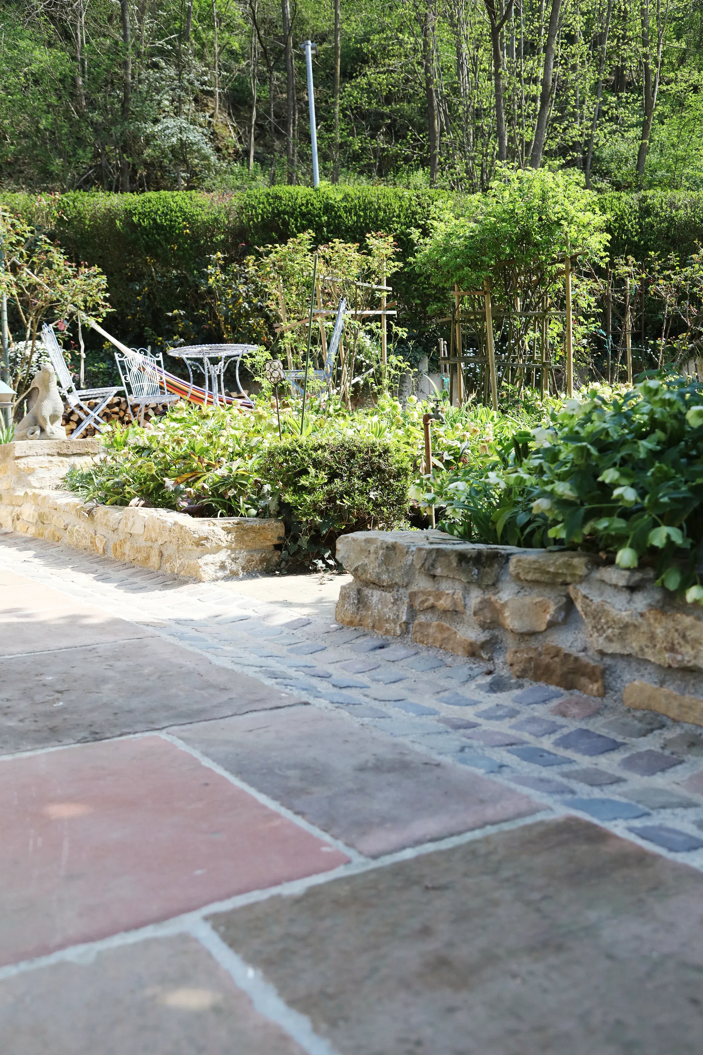 Gewachsener Garten mit historischen Bodenplatten und Natursteinpflaster