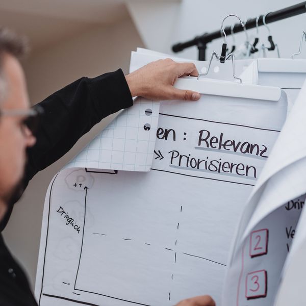 Mitarbeiter auf der Suche nach Informationen auf Flipchart-Bögen