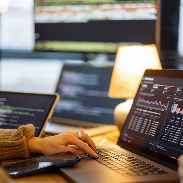 Ein Mitarbeiter oder eine Mitarbeiterin vor einem geöffneten Laptop