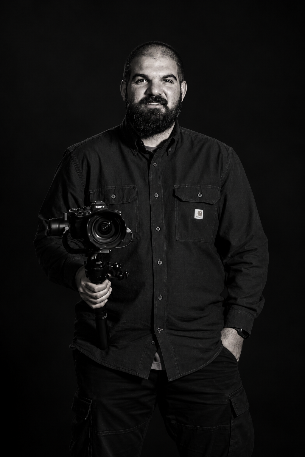 Portrait of the filmmaker behind NINETY TWO holding a camera, in black and white
