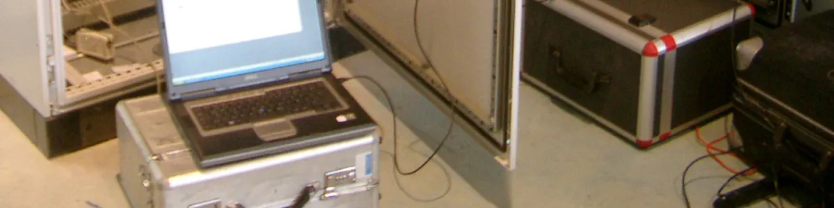 Laptop auf einem Messkoffer bei der Prüfung eines Schaltschranks