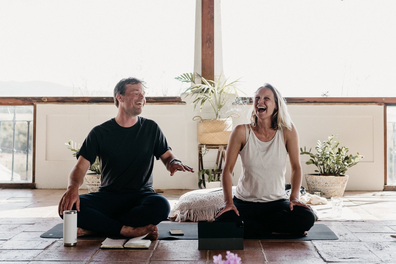 Ruby and Thijs laughing together on yoga mats
