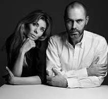 Zwart-wit portret van een man en een vrouw. De vrouw ondersteunt haar hoofd met haar hand en de man zit met zijn armen over elkaar. Beiden hebben een kalme uitdrukking.