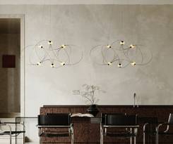 To Munari pendler svæver i luften som lysende kunstværker. Det organiske og skulpturelle design med mange lyskilder skaber dramatisk effekt over spisebordet i stilrent interiør.