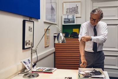 Dette billede viser en Bestlite Limited Edition bordlampe stående på et bord, hvor den bliver betragtet af en mand