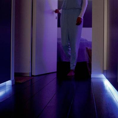 Dette billede viser et gangparti, hvor der lyser blåt lys fra gulvet