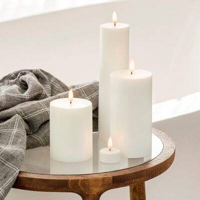 Dette billede viser tre LED-bloklys og et enkelt LED-fyrfadslys stående på et sidebord