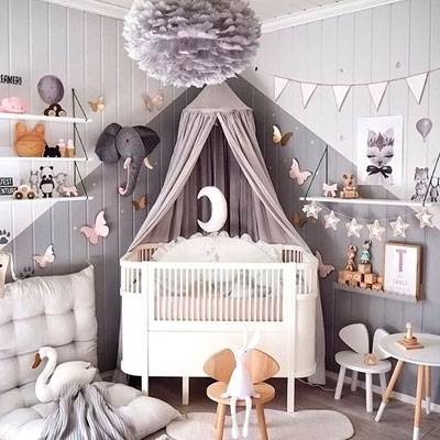 Esta imagem mostra um candeeiro de teto Eos de penas cinzentas da UMAGE pendurado no teto de um quarto de criança