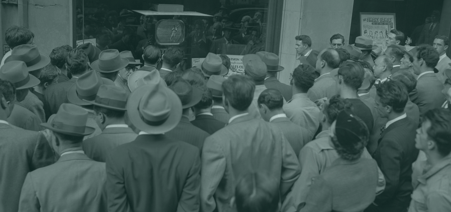 Crowd of people watching a baseball game on a screen in the street
