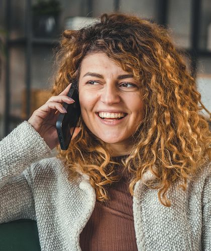 Frau auf dem Sofa am Telefonieren