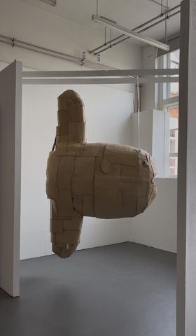 A large cardboard sculpture hanging from ceiling