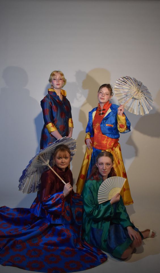 Photo of four female models in colourful japanese-style dresses, holding fans and parasols