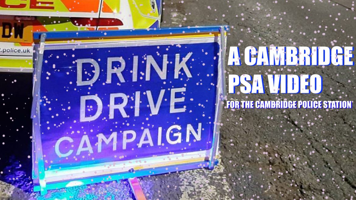 A police car and sign with "Drink Drive Campaign" text, promoting a Cambridge PSA video by the police station, with snowflakes overlay.