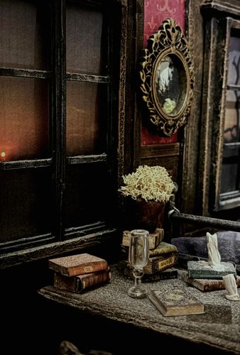 Illustration of an old fashioned room with an ornate mirror and a desk covered in books, and an empty glass