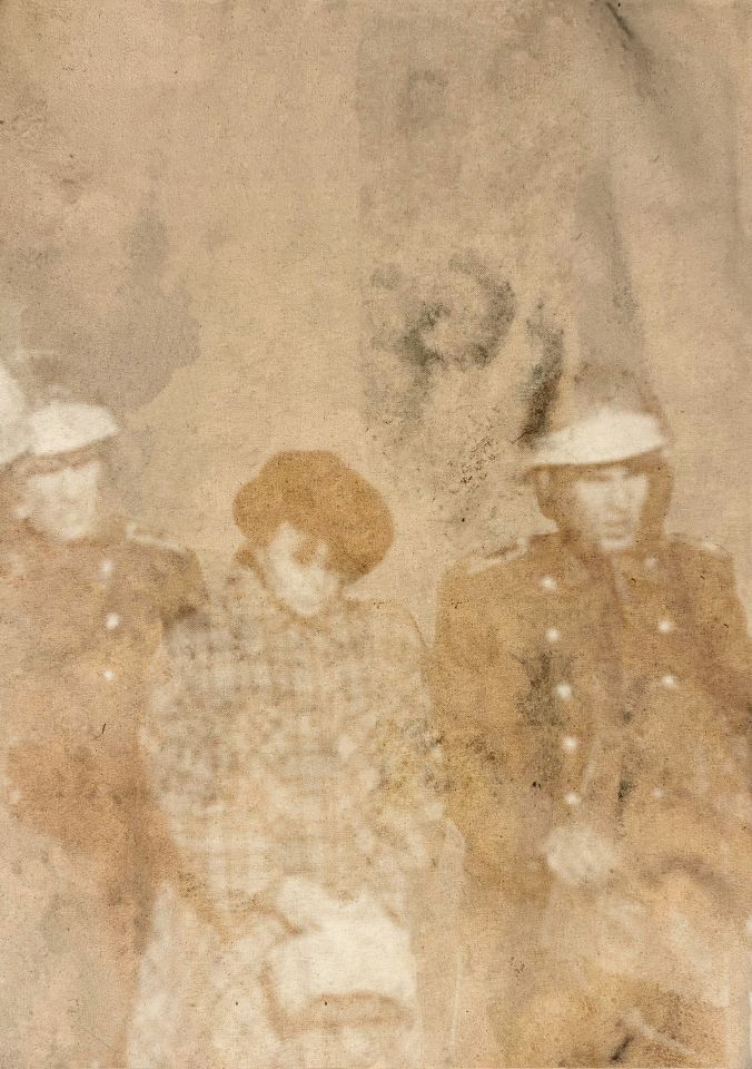 Faded sepia photo of two men in uniforms either side of woman in coat with handbag