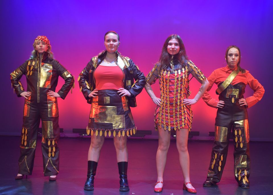 Photo of four female models posing in different outfits