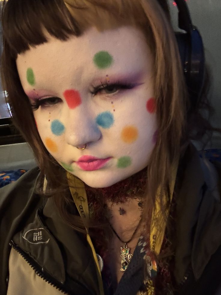 Young woman with white paint and coloured spots on face