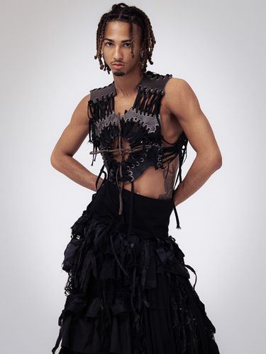 Male model wearing black skirt and threaded leather short top