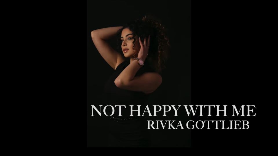 Woman posing with hands in hair against dark background, text reads "Not Happy With Me, Rivka Gottlieb."