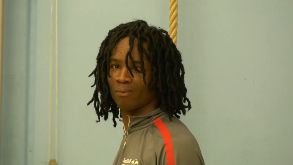 Film still of young man with dreadlocks in gym