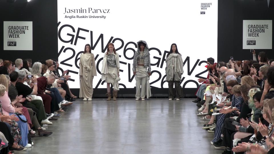 Four female models lined up in front of screen on GFW2026 catwalk wearing various beige and grey outfits