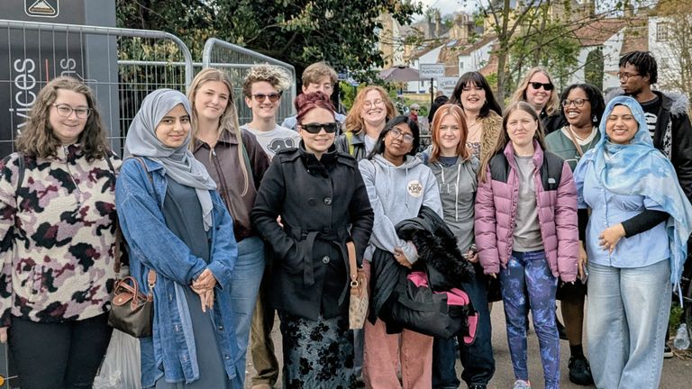 Fifteen creative writing students standing outside