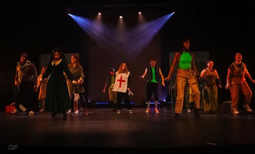 Actors on stage in dramatic lighting, wearing diverse costumes, with a focus on dynamic poses and expressive movements.