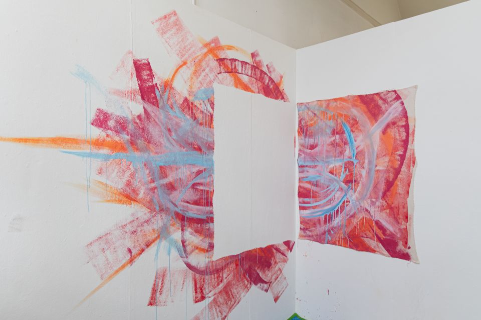 Fine art piece of lue, red and orange paint, the central square removed and stuck on wall next to it