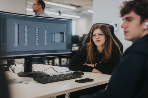 A male and female student use game design software in ARU's game development studio, Cambridge