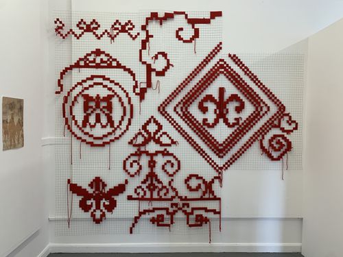Photo of various patterns sewed in red thread on wire mesh