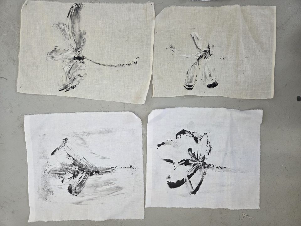 Four pieces of material with plant-like black designs