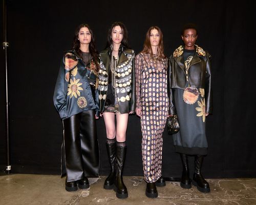 Four female models posting in black costumes with different patterns