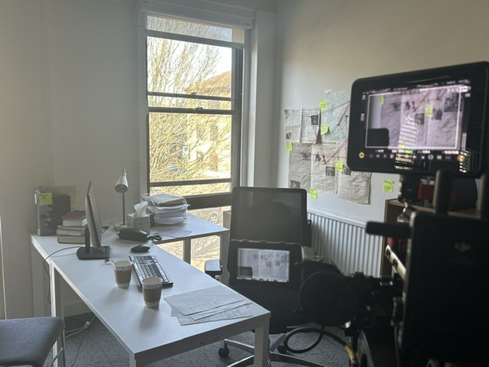 Photo of set for Pentacide film showing office with documents pinned to wall