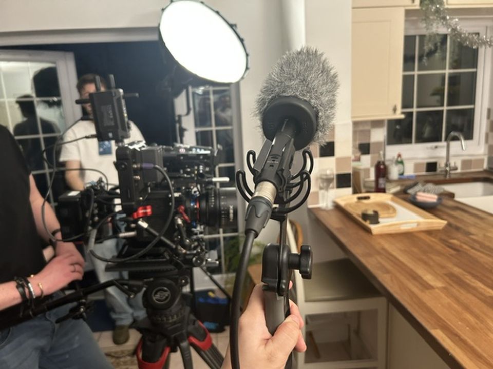 Photo of film crew from perspective of someone holding mic boom