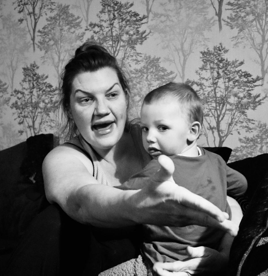 Black and white photo of mother holding baby and looking annoyed