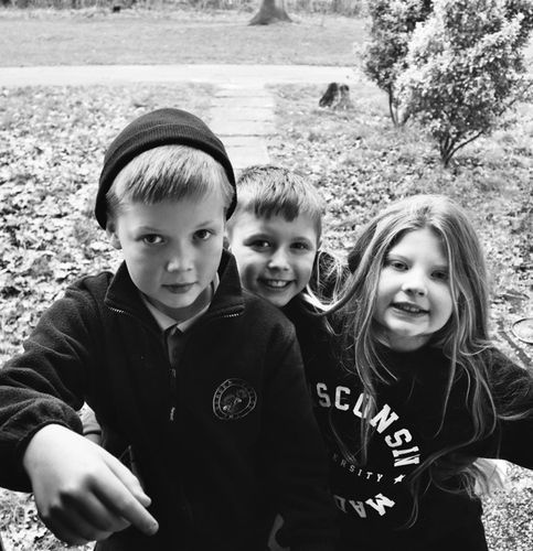 Black and white photo of three children looking at camera