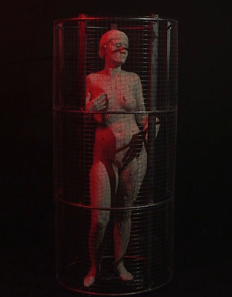 Photo of a statue of a woman inside a cylindrical cage