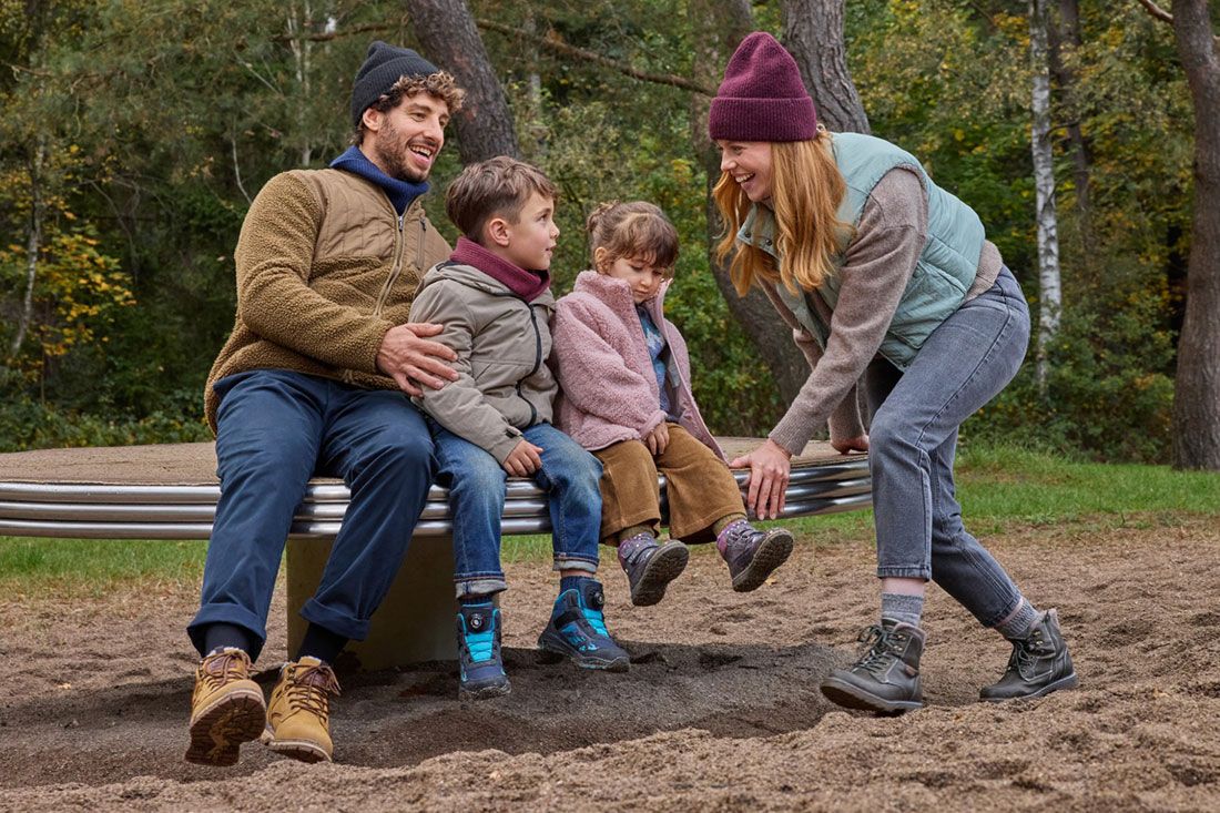 Eine Familie sitzt auf einem Karussell auf einem Spielplatz im Park.