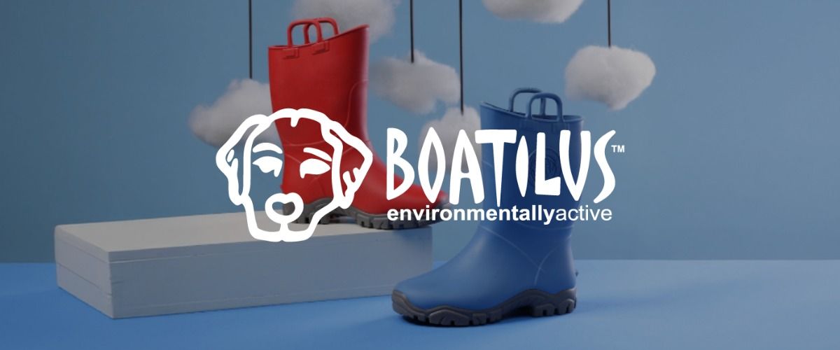 Ein blauer und ein roter Gummistiefel auf blauem Hintergrund mit flauschigen Wolken. Das Logo der Marke BOATILUS überlagert das Bild.