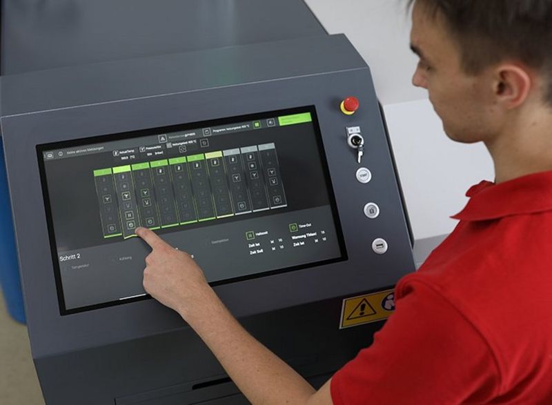A person operates the display of an automatic soldering machine.