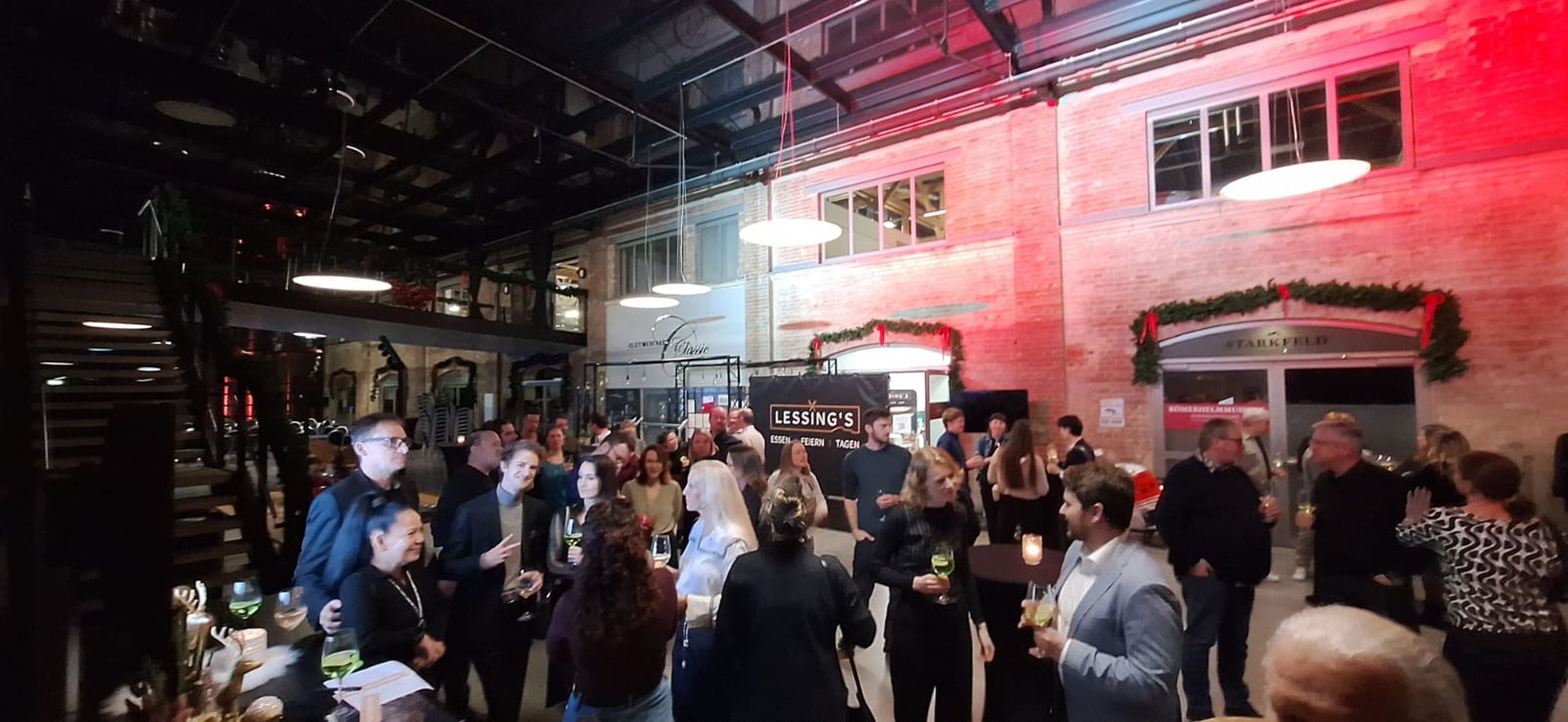 Viele Menschen stehen im Eingangsbereich des Restaurants und trinken gemeinsam.