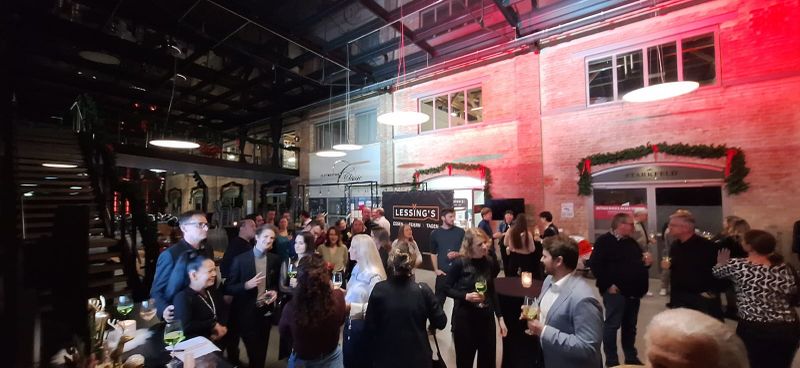 Viele Menschen stehen im Eingangsbereich des Restaurants und trinken gemeinsam.