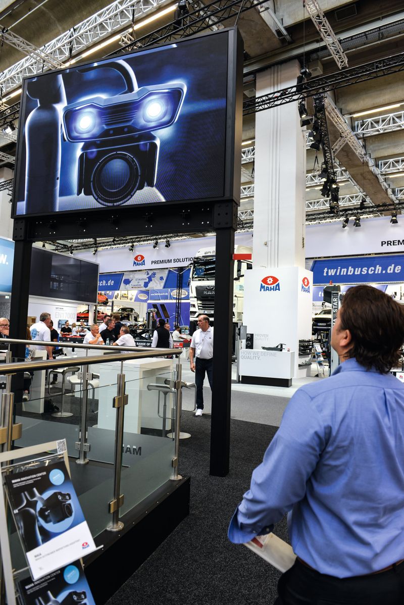 Eine Person schaut auf einen Bildschirm auf einer Messe auf dem MAHA Stand.
