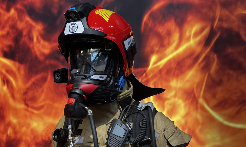 Feuerwehrausrüstung vor einem feurigen Hintergrund, komplett ausgestattet mit Schutzausrüstung und Kommunikationsgeräten.