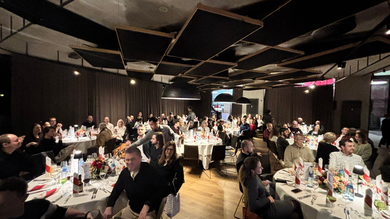 Die Busse Mitarbeiter sitzen gemeinsam beisamen an mehreren Runden Tischen.