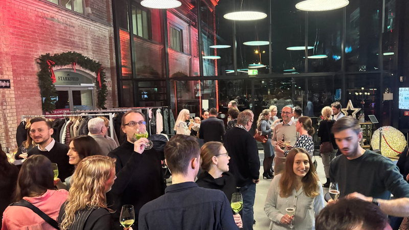 Viele Personen tinken gemeinsam fröhlich im Eingangsbereich des Restaurants.