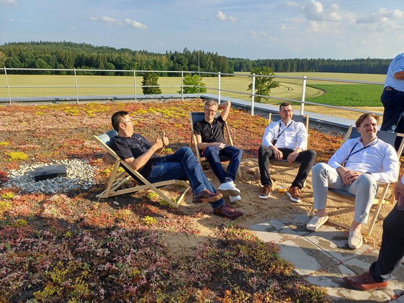 Several people are sitting comfortably in chairs on a terrace.