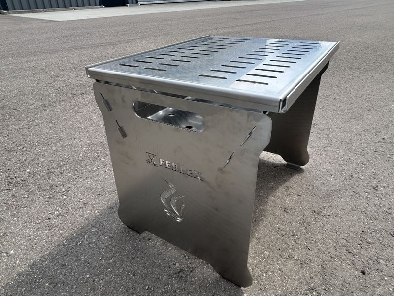 Ein kleiner Grill steht auf dem Boden.
