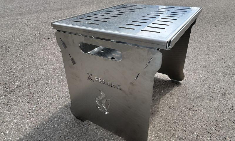 Ein kleiner Grill steht auf dem Boden.