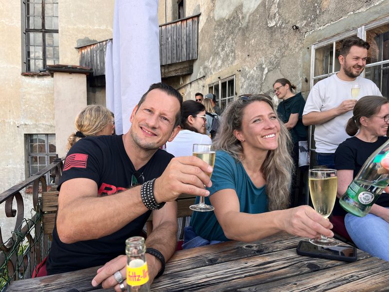 Personen stoßen mit Getänken an.